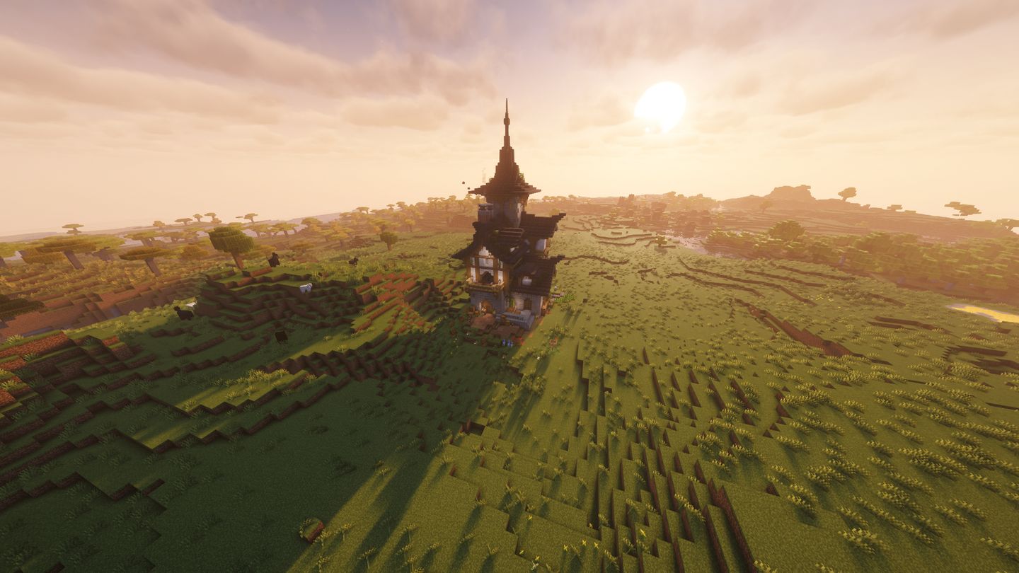 Fachwerkhaus mit spitzem Turm auf einem Hügel, im Gegenlicht der tiefstehenden Sonne.